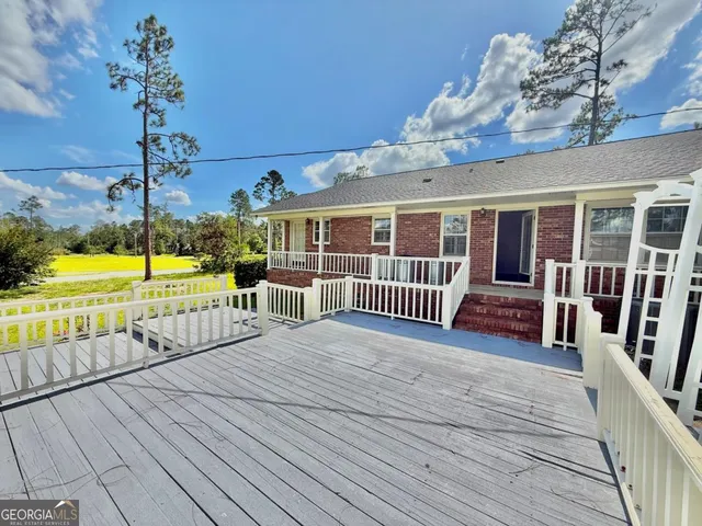 a view of a house with a yard and potted plants