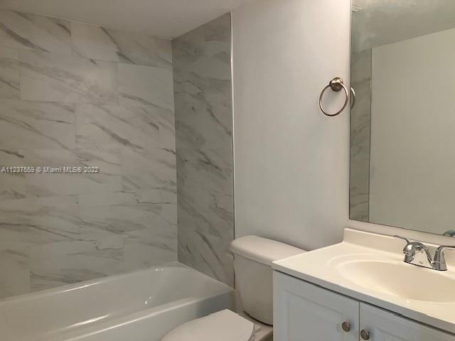 2910 Southeast 13th Road, Unit 10544 Homestead, FL 33035 - Photo 4 of 7 a bathroom with a granite countertop sink a toilet and shower