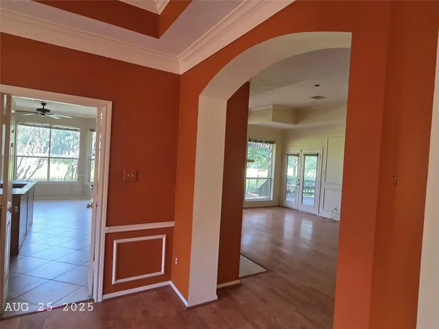 a view of a hallway with wooden floor and a living room