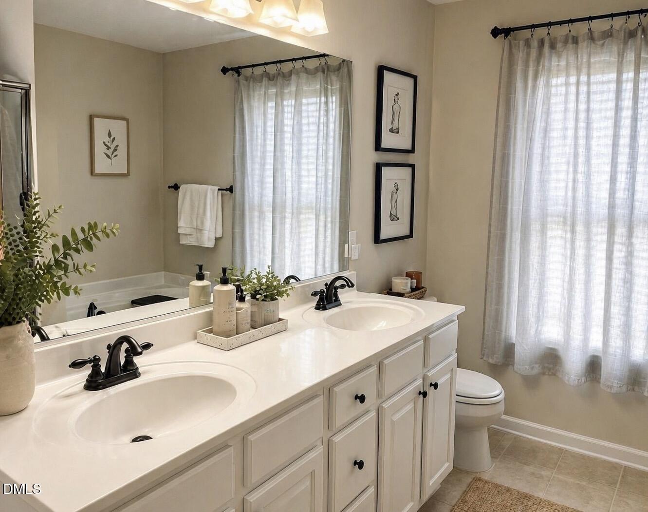 5539 Nur Lane Raleigh, NC 27606 - Photo 13 of 20 a bathroom with a sink a toilet and a large mirror