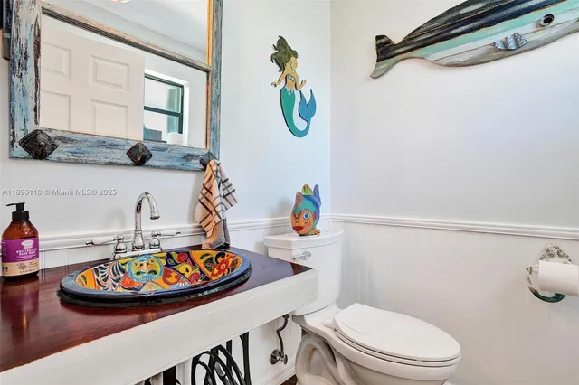 a bathroom with a toilet a sink and a mirror