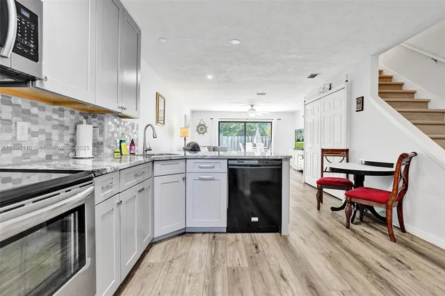 a kitchen with a sink a stove and chairs
