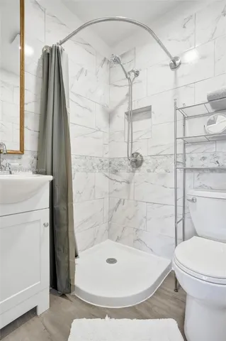 a bathroom with a sink a toilet and shower