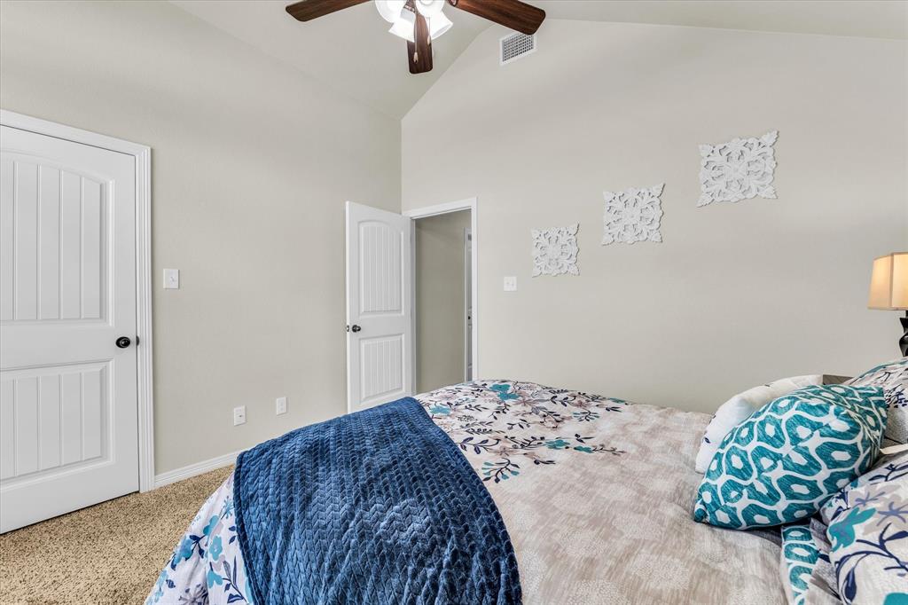 814 Springdale Circle Lorena, TX 76655 - Photo 22 of 37 Vaulted ceiling with a wood-finish ceiling fan, neutral wall paint, white paneled doors, and plush carpeting