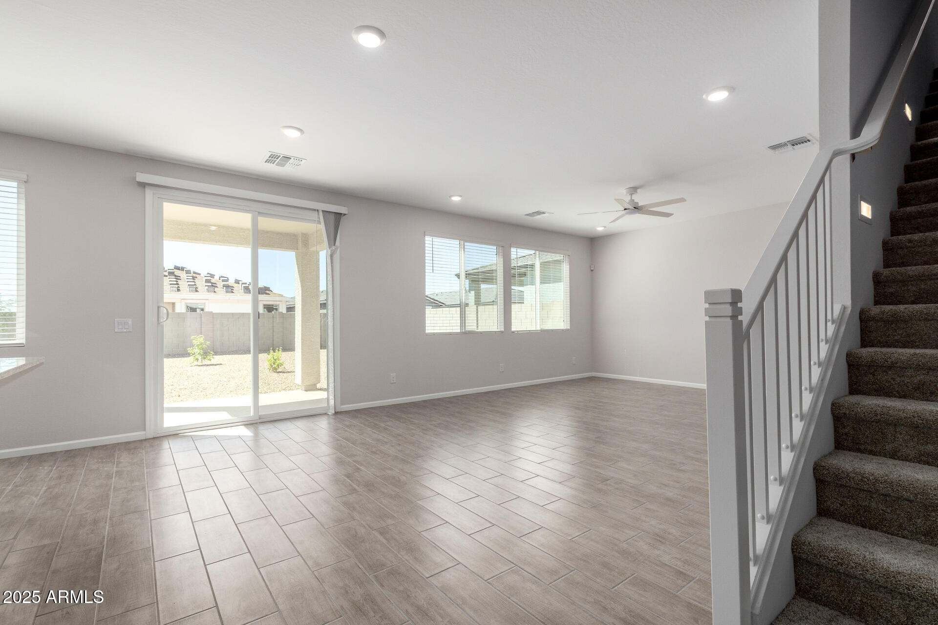 18207 West Daley Lane Surprise, AZ 85387 - Photo 11 of 40 a view of an empty room with wooden floor and a window