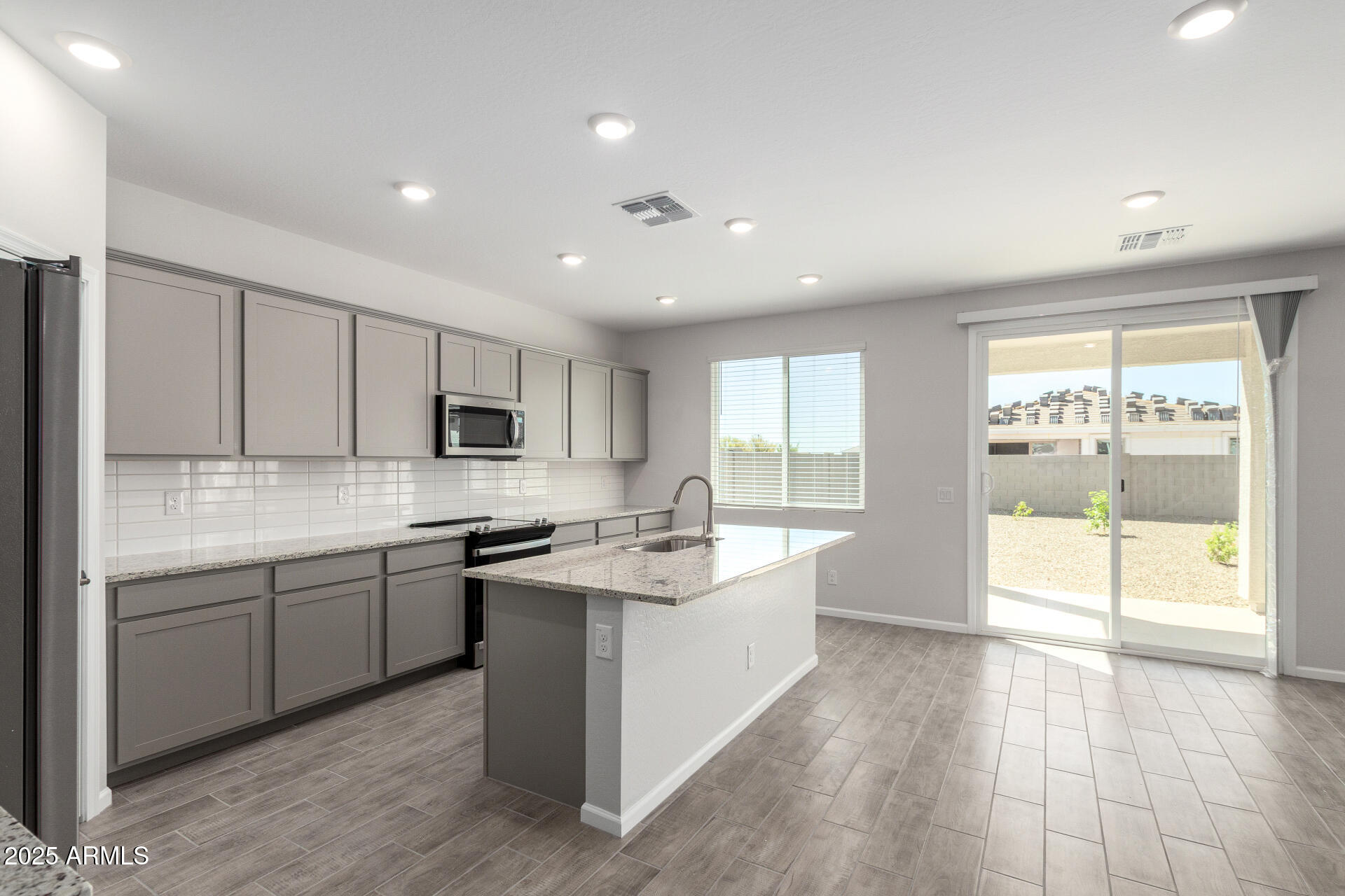 18207 West Daley Lane Surprise, AZ 85387 - Photo 13 of 40 a large kitchen with stainless steel appliances granite countertop a lot of counter space and a sink