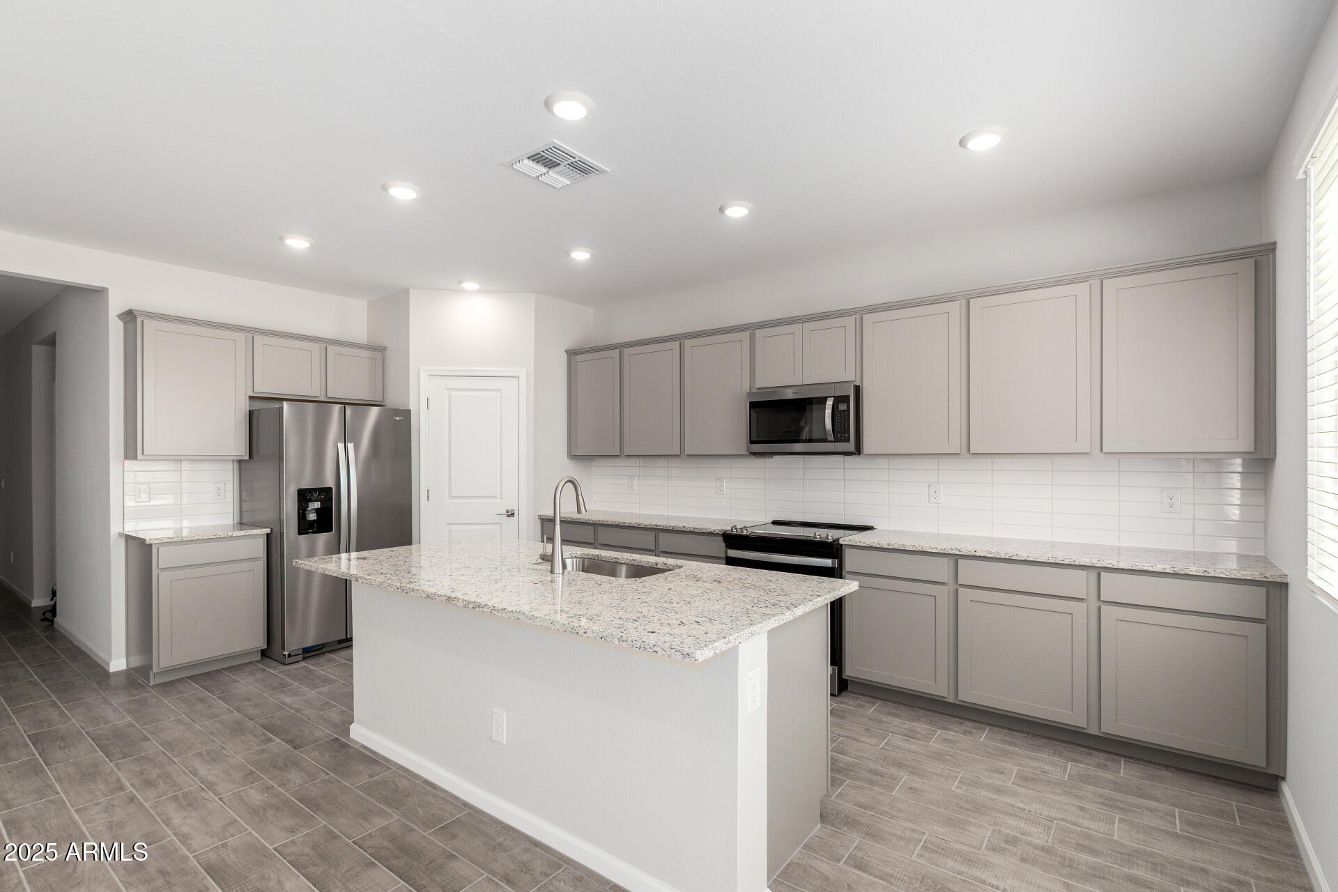 18207 West Daley Lane Surprise, AZ 85387 - Photo 14 of 40 a kitchen with a sink stainless steel appliances and white cabinets