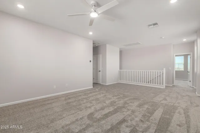 en empty room with windows and ceiling fan