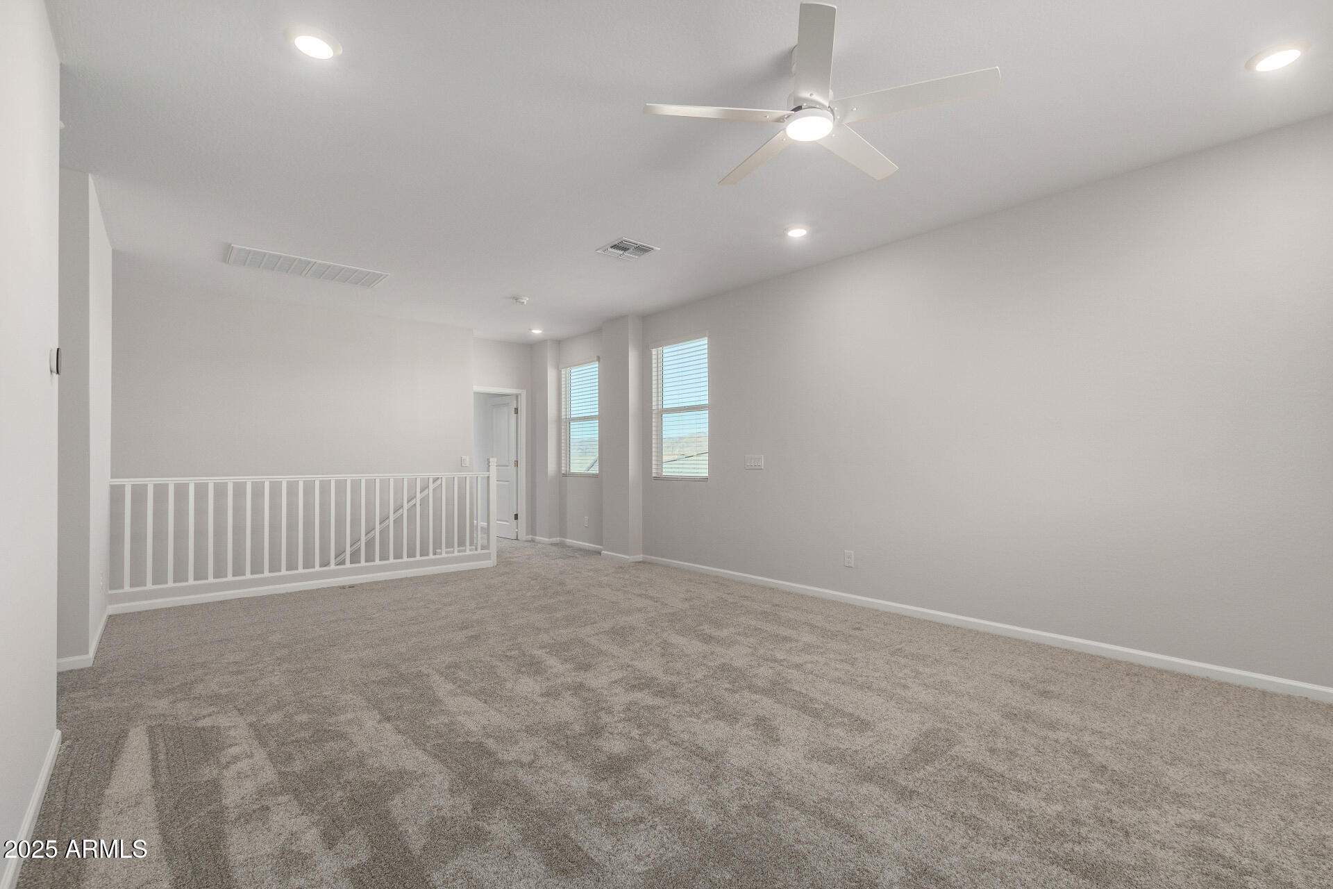 18207 West Daley Lane Surprise, AZ 85387 - Photo 21 of 40 an empty room with chandelier fan and windows