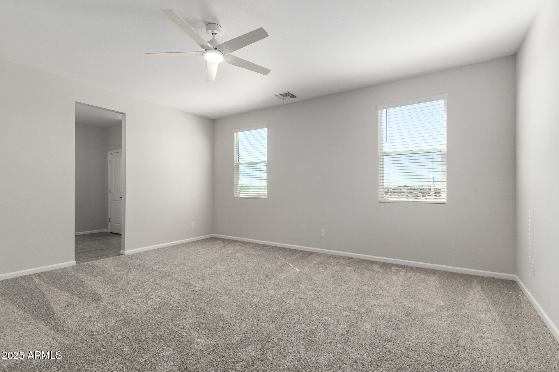 18207 West Daley Lane Surprise, AZ 85387 - Photo 23 of 40 an empty room with windows and fan