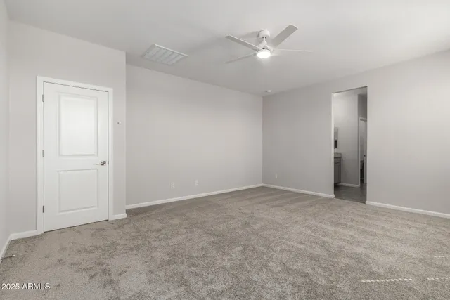 an empty room with a ceiling fan and a window