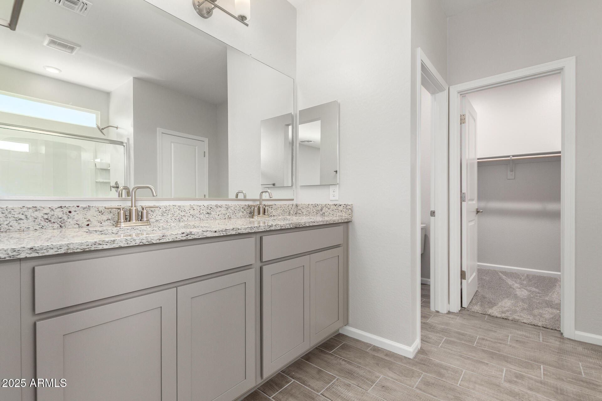 18207 West Daley Lane Surprise, AZ 85387 - Photo 26 of 40 a bathroom with a granite countertop sink and a mirror