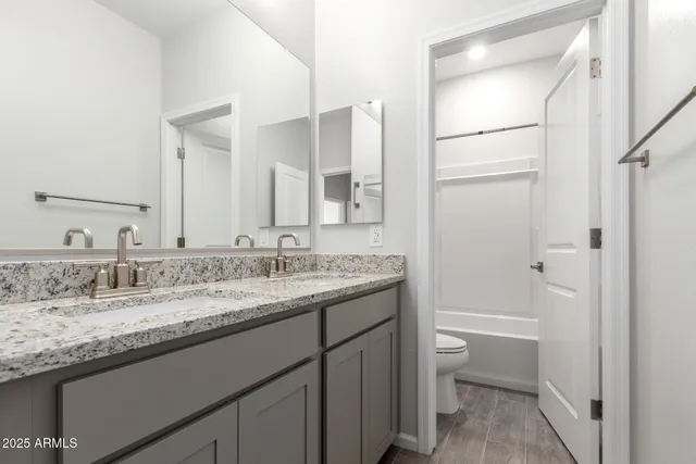 a bathroom with a granite countertop sink toilet and shower