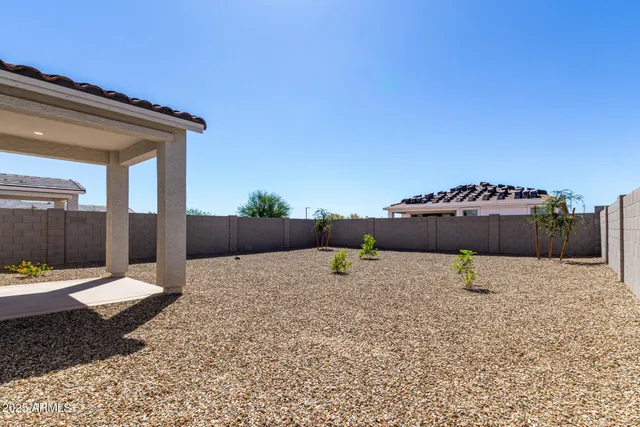 a backyard of a house with table and chairs