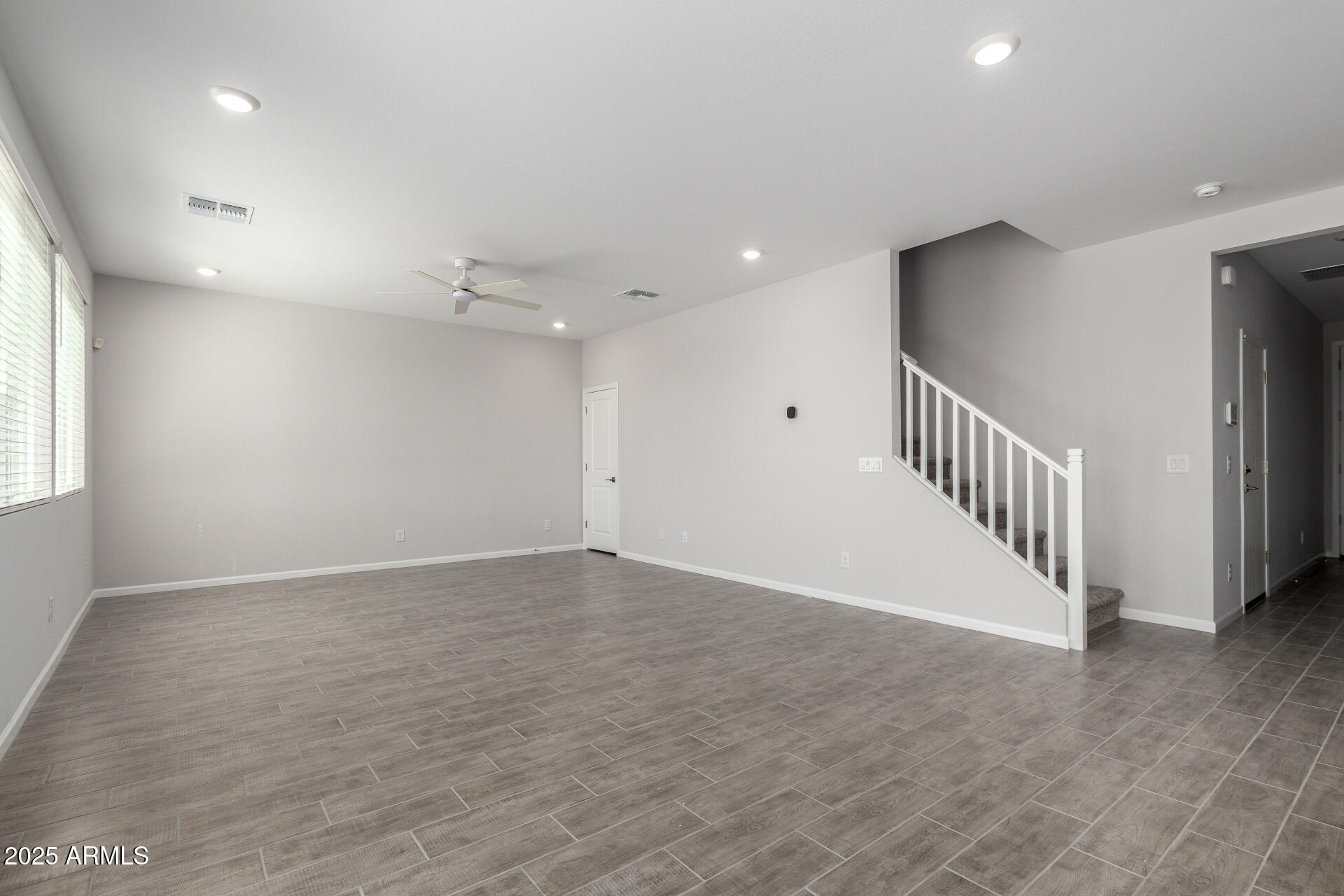 18207 West Daley Lane Surprise, AZ 85387 - Photo 8 of 40 a view of an empty room with wooden floor
