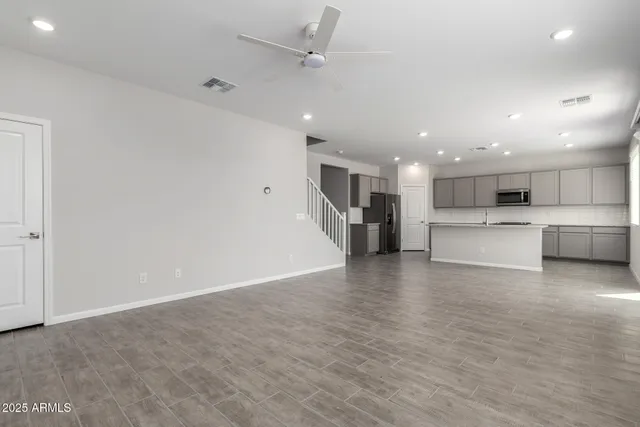a view of kitchen with kitchen island a sink wooden floor and a refrigerator