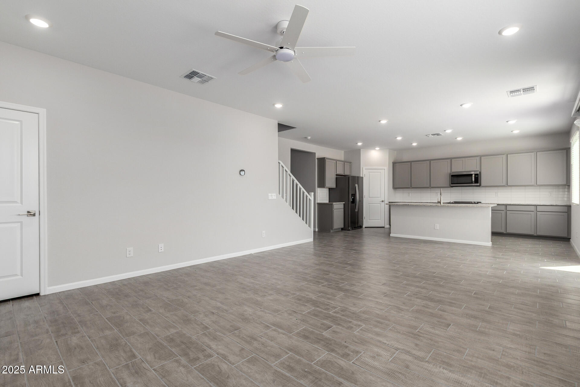 18207 West Daley Lane Surprise, AZ 85387 - Photo 9 of 40 a view of kitchen with kitchen island a sink wooden floor and a refrigerator
