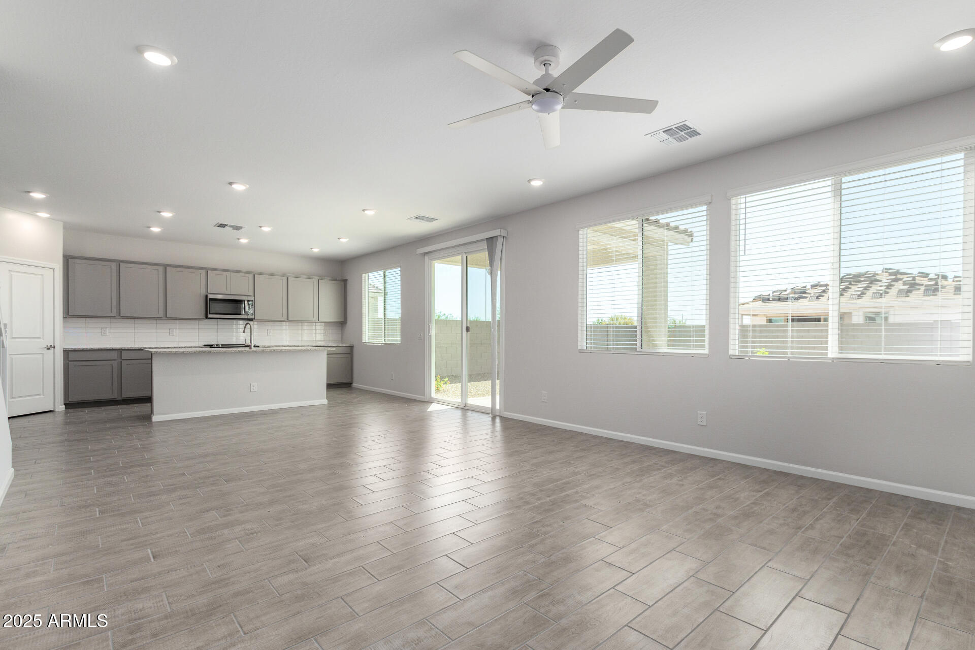 18207 West Daley Lane Surprise, AZ 85387 - Photo 10 of 40 a view of an empty room with wooden floor and a window