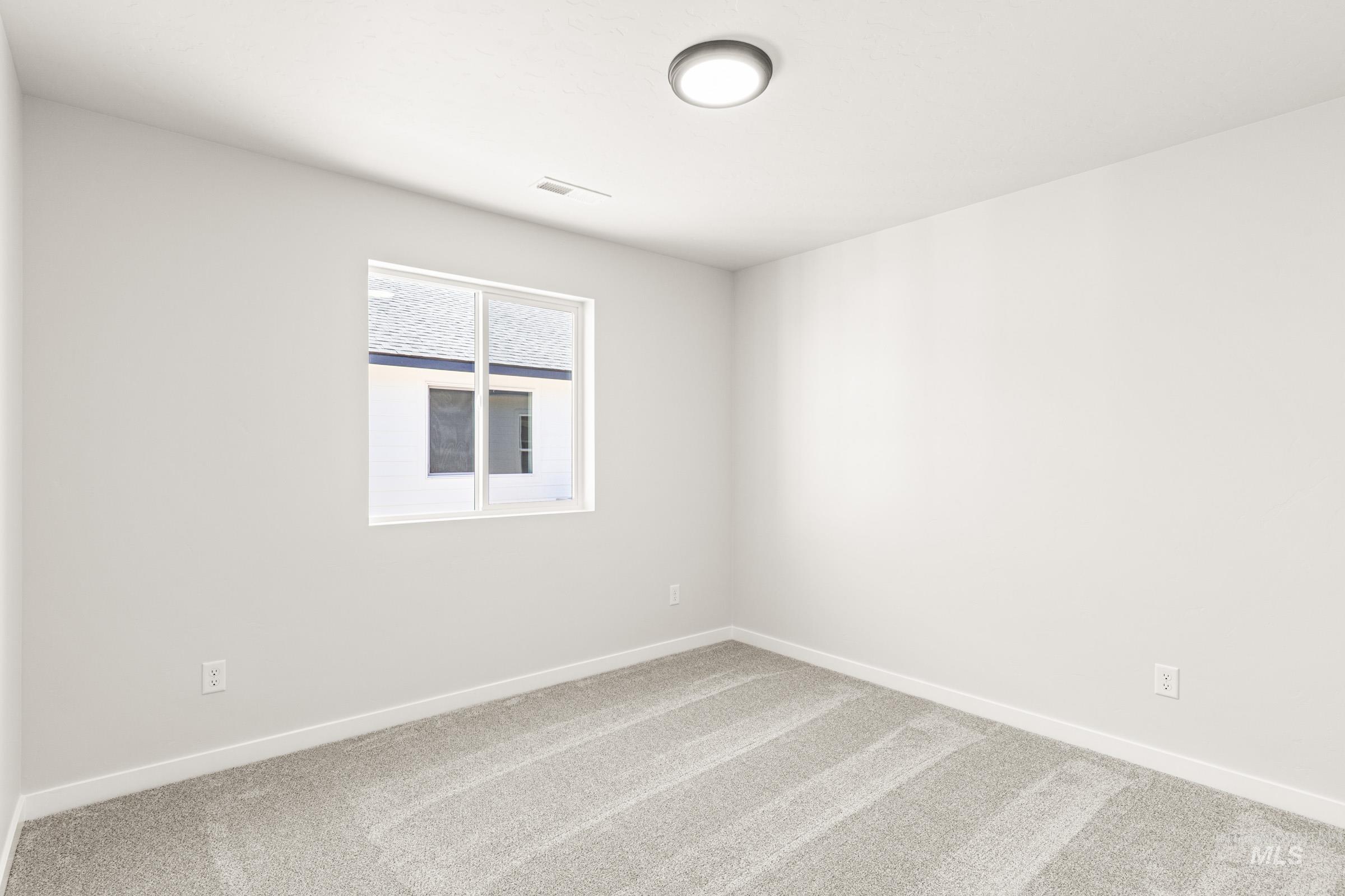1077 West Jasper Street Meridian, ID 83642 - Photo 12 of 19 Bright interior space featuring a window with white trim, light gray textured carpeting, white baseboards, and a flush-mount ceiling light fixture