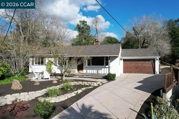 a view of a patio with table and chairs with wooden fence and large trees