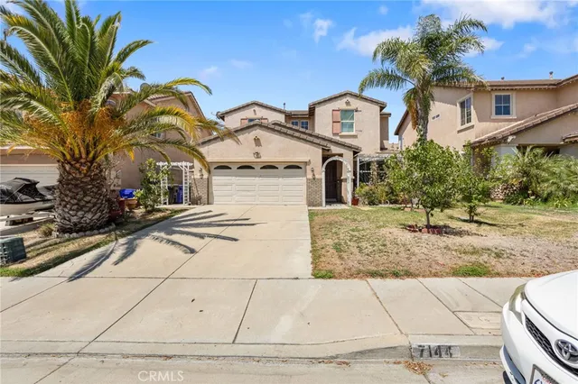 a view of a white house with a tree and plants