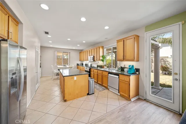 a kitchen with stainless steel appliances granite countertop a refrigerator and a stove top oven