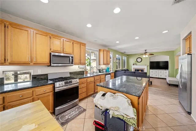a kitchen with stainless steel appliances granite countertop a stove top oven a sink a counter space and cabinets