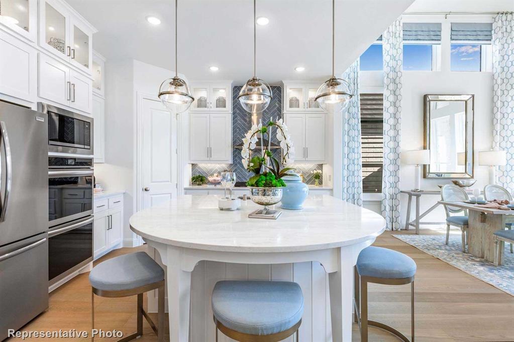 a kitchen with stainless steel appliances a dining table chairs and chandelier