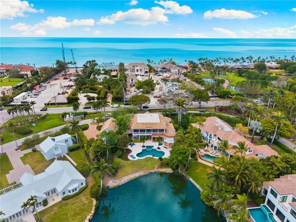 an aerial view of residential houses with outdoor space and lake view