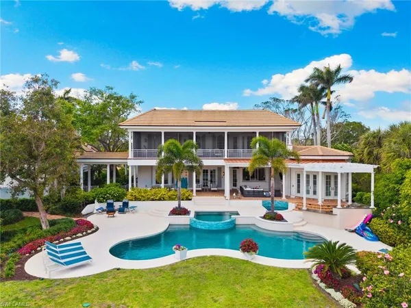 a view of a house with pool fire pit a chairs and a table