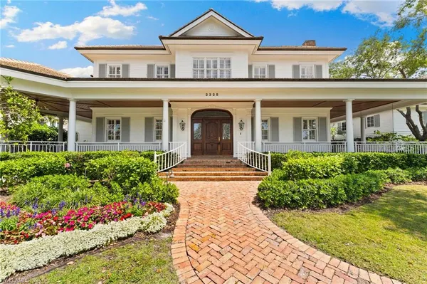 a front view of a house with a yard and potted plants
