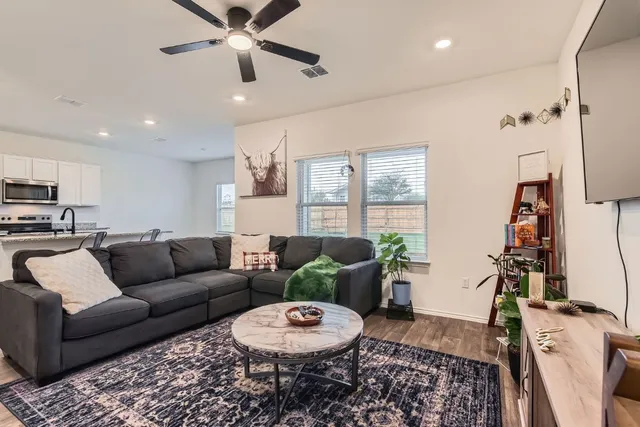 a living room with furniture and a wooden floor