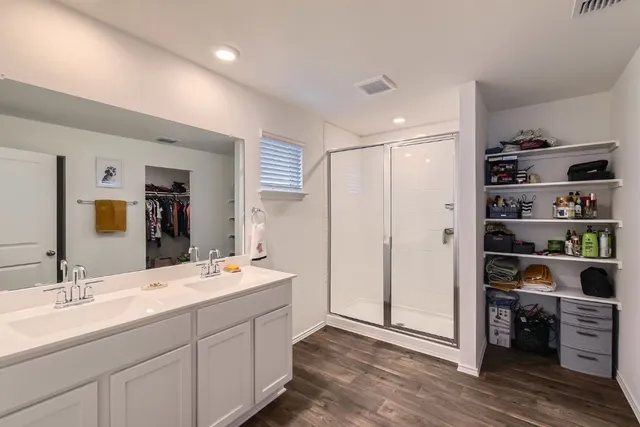 a bathroom with a double vanity sink mirror and shower