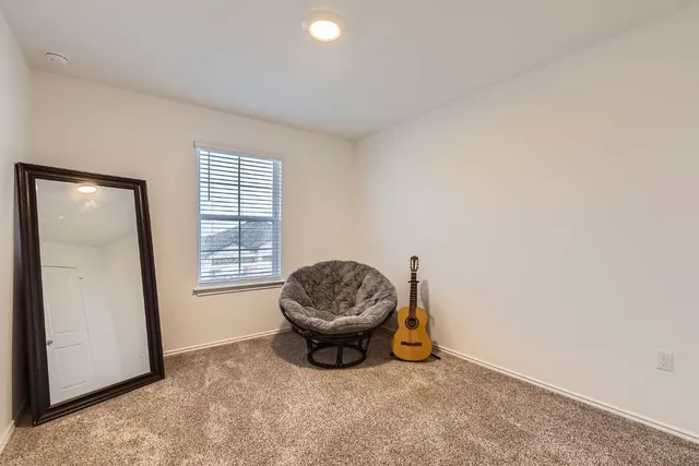 an empty room with a chair and white walls
