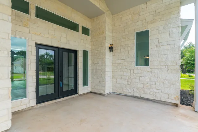 a view of empty room with wooden floor and kitchen