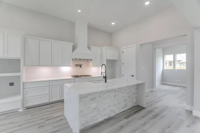 a view of a kitchen with kitchen island a sink stainless steel appliances and cabinets