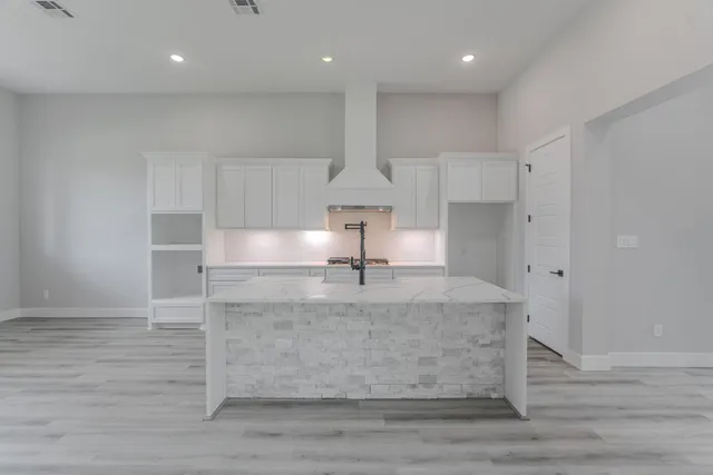 a kitchen with kitchen island a sink appliances cabinets and a counter top space
