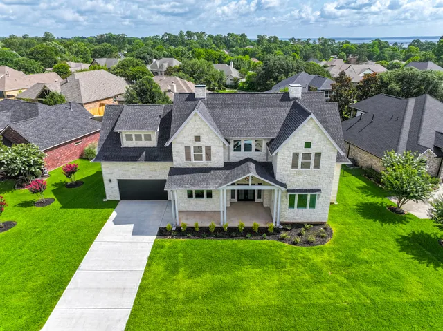 a aerial view of a house with a yard and lake view