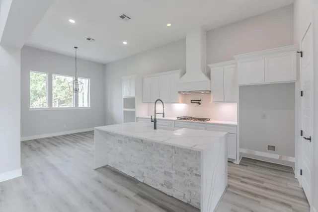 a kitchen with kitchen island a sink appliances and cabinets
