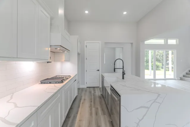 a kitchen with kitchen island a sink stove and wooden floor