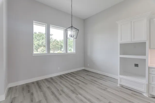 a view of a hallway with wooden floor and entryway