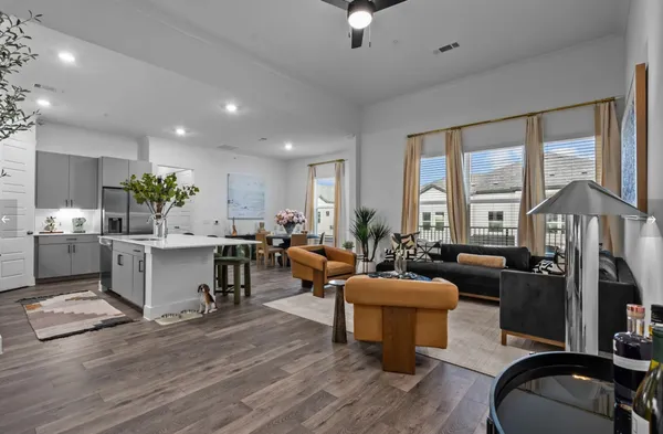 a living room with furniture a flat screen tv and large windows