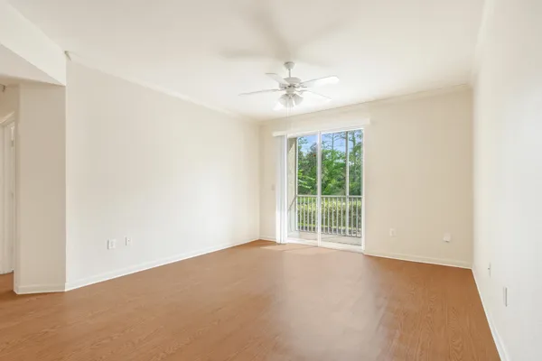 an empty room with windows and fan