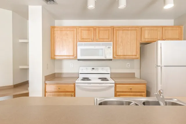 a kitchen with a stove a refrigerator and a sink
