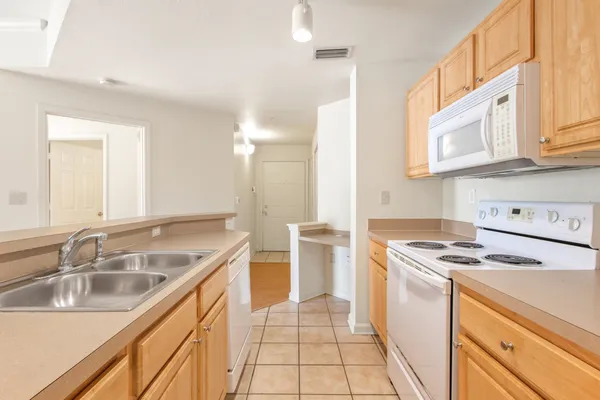 a kitchen that has a sink a stove and a microwave