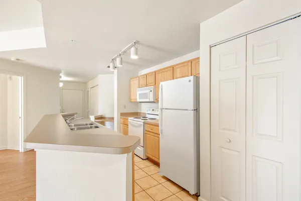 a kitchen with white cabinets and refrigerator