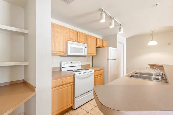 a kitchen with a refrigerator a stove top oven a sink and cabinets