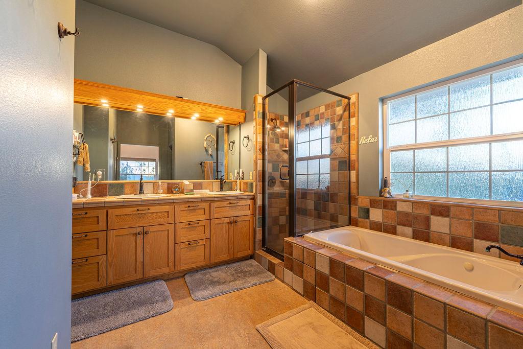 10132 Ranch Road Rough and Ready, CA 95975 - Photo 24 of 54 a spacious bathroom with a double vanity sink a large mirror and a bathtub