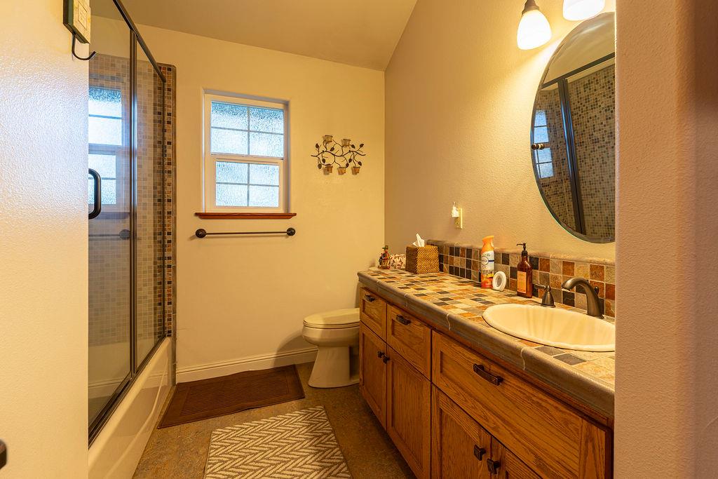 10132 Ranch Road Rough and Ready, CA 95975 - Photo 30 of 54 a spacious bathroom with a granite countertop sink mirror and a toilet