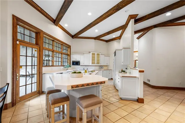 a room with stainless steel appliances kitchen island granite countertop furniture and a large window